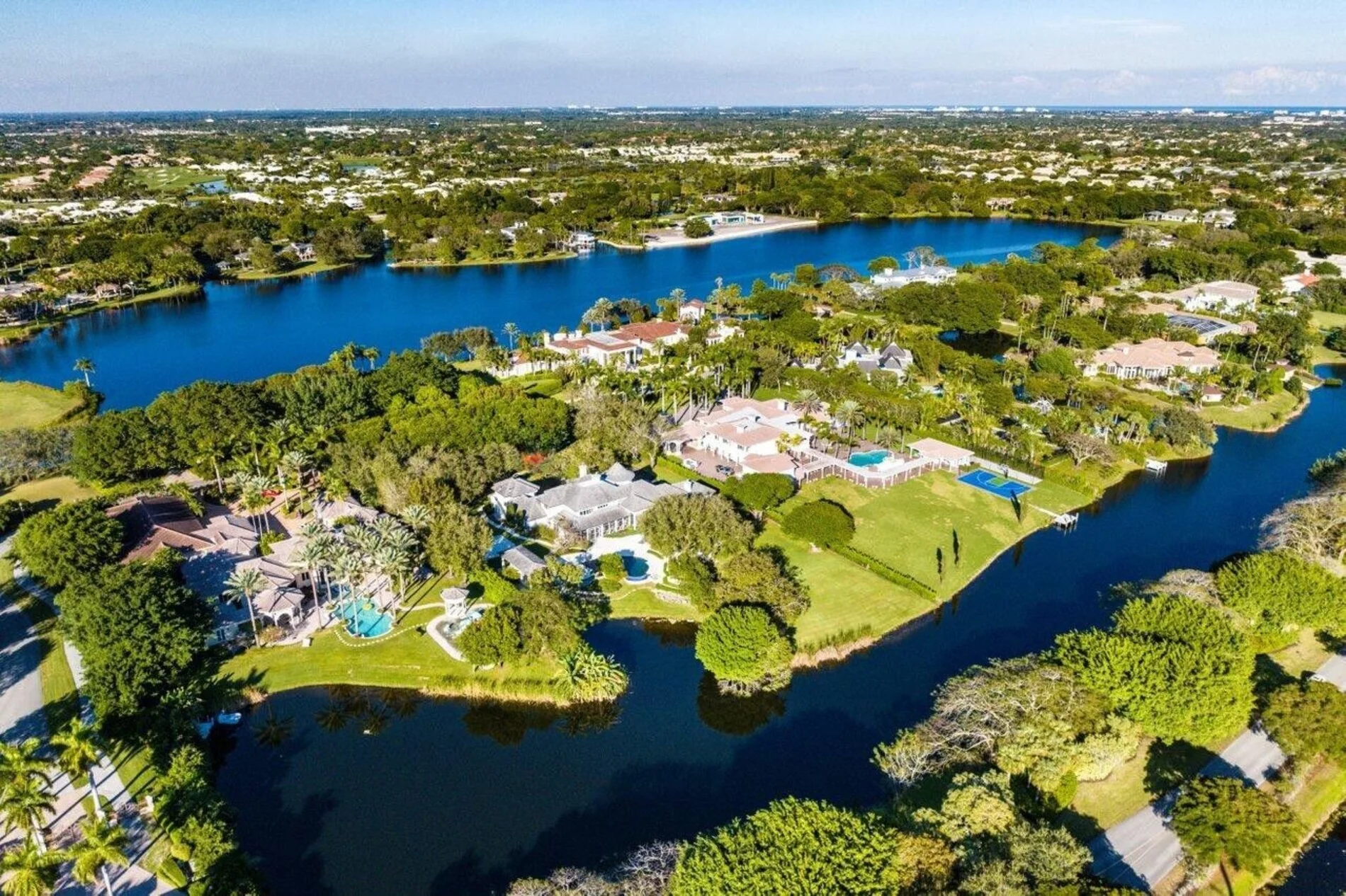 Aerial view of Le Lac in Boca Raton, FL featuring luxury estates, private lakes, lush landscaping, and exclusive waterfront homes.